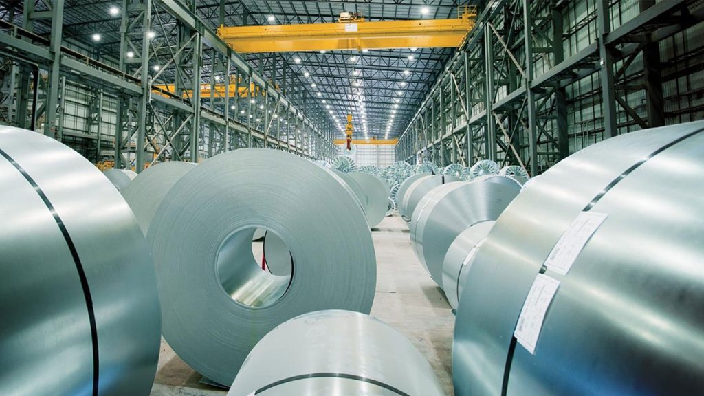 Steel coil warehouse with overhead crane and rolled steel coils in industrial facility